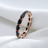Bague diamant noir avec un anneau couleur rose gold serti de pierres ovales noires.