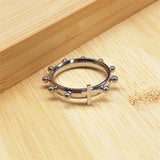 Bague dizainier en acier inoxydable argenté avec dix boules et une croix.