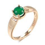 Bague emeraude or rose 585 avec une zircone verte ronde et de petits zircones.