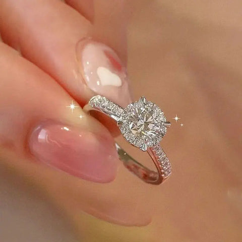 Bague en diamant moissanite en argent sterling avec une pierre ronde et un anneau incrusté de pierres.