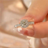 Main de femme portant une bague en diamant moissanite en argent sterling.