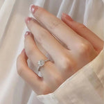 Bague en diamant moissanite en argent avec anneau pavé de pierres porté sur l'annulaire d'une femme.
