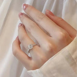 Bague en diamant moissanite en argent avec anneau pavé de pierres porté sur l'annulaire d'une femme.
