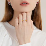 Femme portant une bague en or 18 carats sur son majeur.