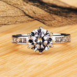 Bague de fiançailles en argent 925 avec une pierre ronde en zircone et de petits strass brillants.