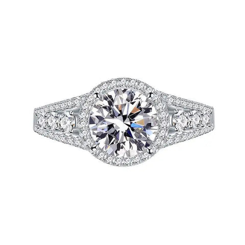 Bague de fiançailles en argent avec un gros zircone central entouré de petites pierres sur son anneau.