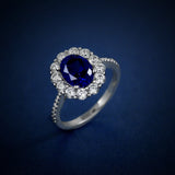 Bague fiançailles saphir en argent avec une zircone bleue ovale entourée de petits zircones blancs.