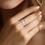 Bague fiançaille unique en argent et moissanite portée sur le majeur d'une femme.