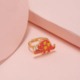 Bague fille en dorée avec un pendentif dinosaure rose.