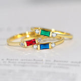 3 bagues fines couleurs dorées posées l'une au-dessus de l'autre.