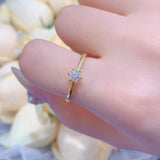 Main de femme portant une bague fine or jaune sur son majeur.