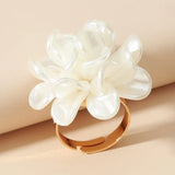 Bague fleur avec un anneau fin doré et une grosse fleur blanche en acrylique.
