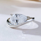 Bague goutte d'eau avec un anneau argenté et une pierre taille poire.