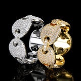 Deux bagues graine de café posées l'une à côté de l'autre, une dorée et une argentée.