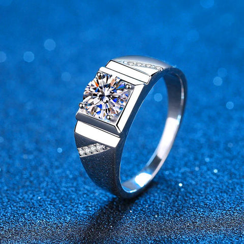 Bague homme luxe en argent avec une pierre principale carrée et des petites pierres incrustées sur l'anneau. 