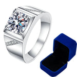 Bague homme luxe avec une pierre moissanite carrée 1 carat et des petites pierres sur les côtés avec sa boîte bleue.