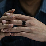 Homme portant une bague homme noire en acier inoxydable sur son majeur.