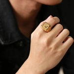 Bague homme pas cher doré avec un motif aigle, portée sur l'index d'un homme.
