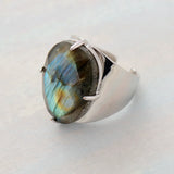 Bague labradorite avec un anneau ouvert couleur argenté et une grosse pierre ovale.