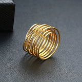 Bague large femme en acier doré avec de multiples anneaux fins.