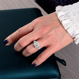 Femme portant une bague luxe en argent 925 avec une pierre carrée blanche en zircone sur son annulaire.