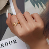 Bague main couleur dorée portée sur l'index d'une femme.