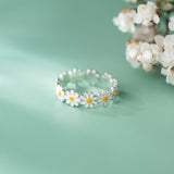 Bague marguerite avec une chaîne de fleurs blanches et jaunes.