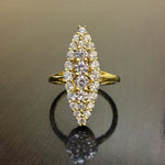 Bague marquise de couleur dorée avec gros plan sur les zircones et un reflet sur la surface.