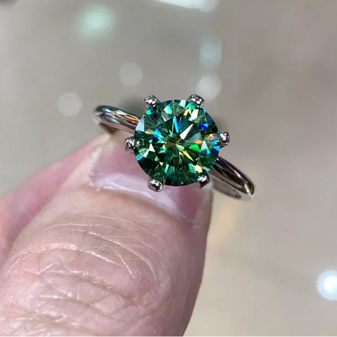 Bague moissanite avec un anneau en argent 925 et une moissanite ronde verte.