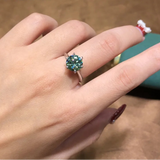 Bague moissanite en argent sterling 925 et moissanite verte, portée sur le majeur d'une femme.