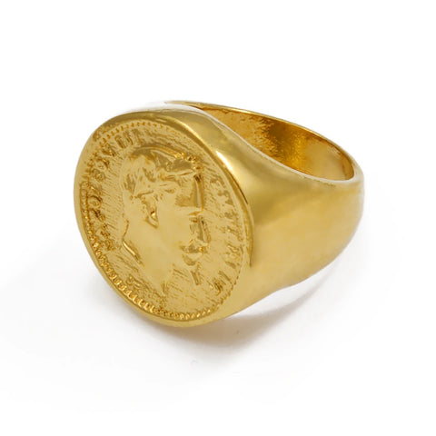 Bague Napoléon dorée avec un motif de pièce de monnaie au centre, sur un fond blanc.
