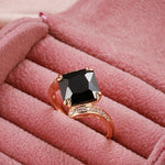Bague noir avec un anneau rose gold serti de pierres et une zircone principale carrée noire.