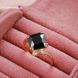 Bague noir avec un anneau rose gold serti de pierres et une zircone principale carrée noire.