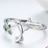 Bague oiseau en argent à taille ajustable avec de petites pierres vertes.