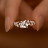 Bague couleur or blanc en argent avec un motif floral délicat et des pierres brillantes.