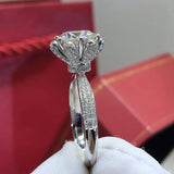Bague couleur or blanc diamant vue de côté, montrant la monture de la moissanite ronde et l'anneau pavé de petites pierres.
