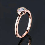 Bague couleur or rose vue de côté, avec une moissanite sertie clos et son reflet.