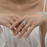 Bague originale argent plaqué or blanc portée sur le majeur d'une femme.