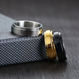 Trois bague pacs femme en acier inoxydable, une argentée, une dorée et une noire.