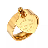 Bague pampille dorée en acier avec l'écriture "Please return to forever love New York 925" sur son pendentif coeur.