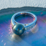 Bague perle de tahiti en argent avec un anneau serti de pierres.