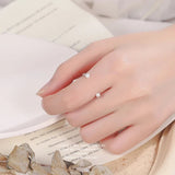 Bague phalange argent portée sur l'index d'une femme.