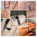 Mains de femme portant élégamment une bague pierre noire pavée de petites pierres noires et blanches.