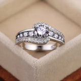 Bague pierre de couleur argent, avec une pierre ovale blanche et des rangées de petites pierres blanches.