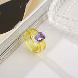 Bague plastique jaune en résine posée sur une table.