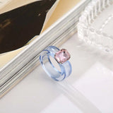 Bague plastique en résine bleu avec une pierre rose rectangulaire.