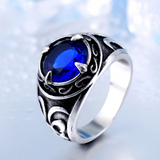 Bague pour homme argentée, avec une pierre centrale de couleur bleu intense.