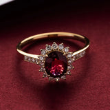 Bague rubis posée sur un tapis de joaillier avec une pierre ovale ornée de petites pierres.