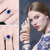 Bague saphir bleu en argent 925 avec un saphir ovale, portée sur un doigt.