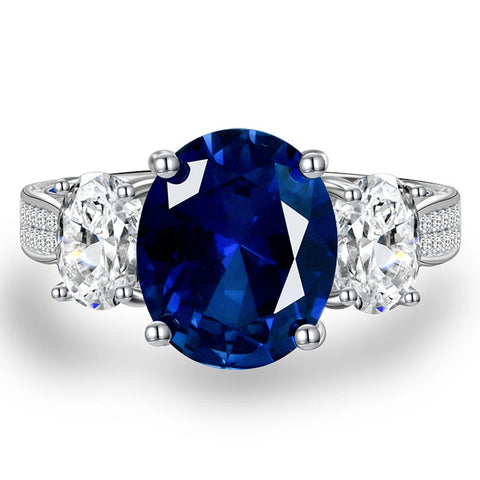 Bague saphir diamant avec un anneau en argent, un saphir ovale bleu et de petits zircones.
